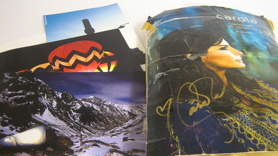 Returned probe materials including a photo of a hot air balloon over snowy mountains and a worn magazine cover featuring the singer Carola